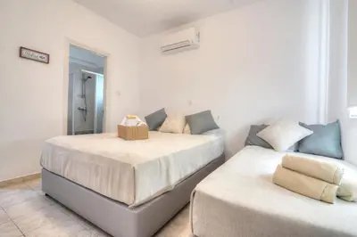 a bedroom with two beds and a mirror and a mirror at Villa Argyro in Ayia Napa
