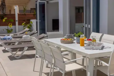 a white dining table and chairs on a patio at SunnyVillas-3BR New Modern Villa-Private Pool-BLG in Paralimni