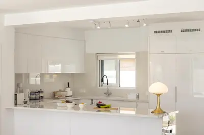 a white kitchen with white cabinets and a lamp at SunnyVillas-3BR New Modern Villa-Private Pool-BLG in Paralimni