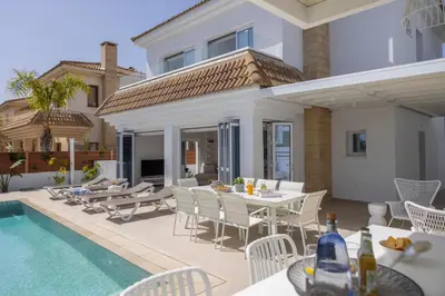 a patio with a table and chairs and a pool at SunnyVillas-3BR New Modern Villa-Private Pool-BLG in Paralimni