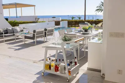 a drink cart on a patio with a view of the ocean at Protaras Elaia Luxury Seafront Villa in Protaras