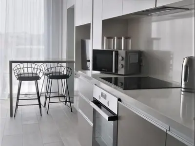 a kitchen with a microwave and a counter with stools at Mythical Sands - Orion in Protaras