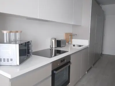 a white kitchen with a microwave and a sink at Mythical Sands - Orion in Protaras