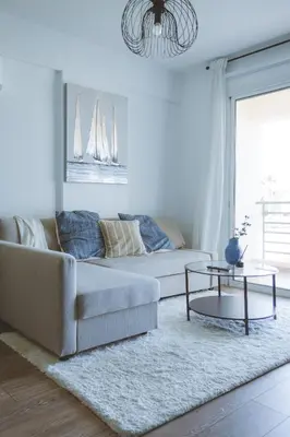 a living room with a couch and a table at Blue Touch Pervolia Paradise near the beach in Larnaka
