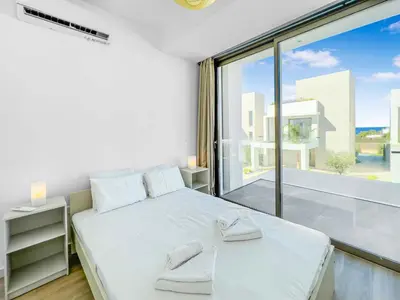 a bedroom with a white bed and a large window at Azure Seaview - Garnet Villa in Protaras
