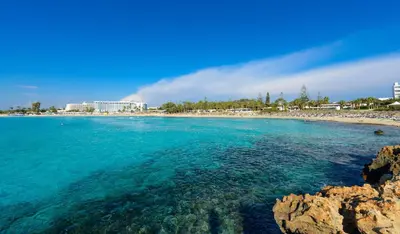 a view of a beach with a resort in the background at Kymma Villa #12 in Ayia Napa