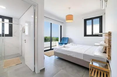 a bedroom with a bed and a walk in shower at By The Beach - Blue Topaz Villa in Protaras