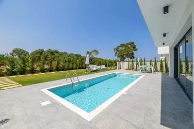 a swimming pool in the backyard of a house at By The Beach - Blue Topaz Villa in Protaras