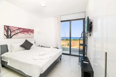 a bedroom with a bed with a view of the ocean at By The Beach - Emerald Seaview Villa in Protaras