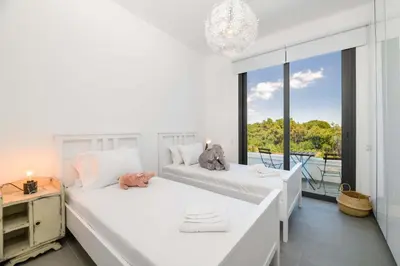 two beds in a room with a large window at By The Beach - Sea Pearl Villa in Protaras