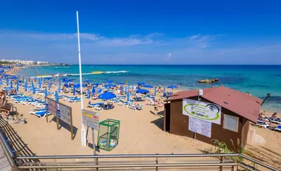 a beach with umbrellas and people on the sand at Sunrise Bay Villa #2 in Protaras