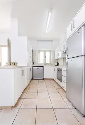 a kitchen with white appliances and a tiled floor at Sunrise Bay Villa #2 in Protaras