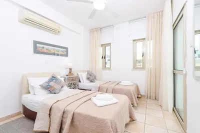 a bedroom with two beds and a couch at Sunrise Bay Villa #3 in Protaras