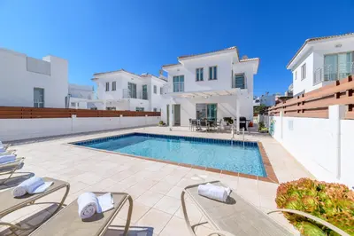 a villa with a swimming pool and white buildings at Sunrise Bay Villa #5 in Protaras