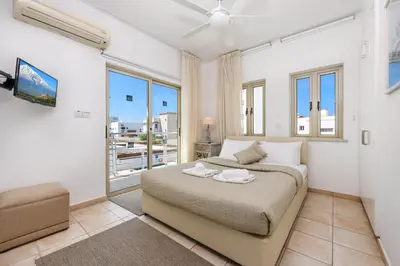 a bedroom with a bed and a large window at Sunrise Bay Villa #5 in Protaras