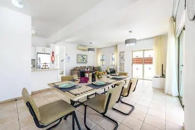 a dining room and living room with a table and chairs at Sunrise Bay Villa #5 in Protaras