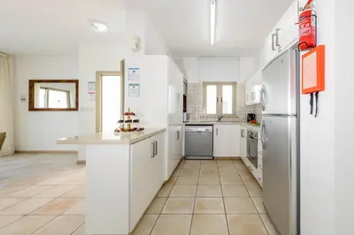 a kitchen with white cabinets and a refrigerator at Sunrise Bay Villa #5 in Protaras