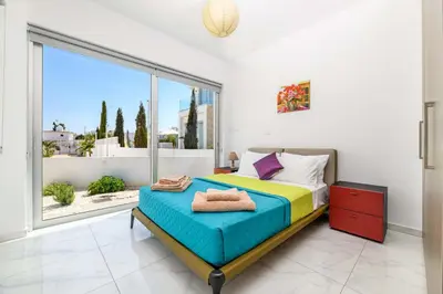 a bedroom with a bed and a large window at Mylos Lifestyle Seaview Villa #15 in Protaras