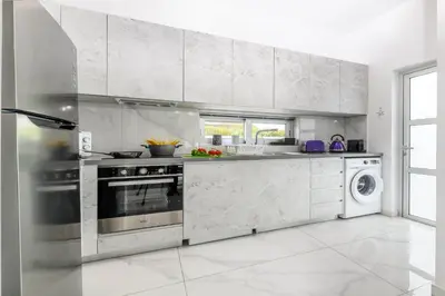 a white kitchen with a stove and a dishwasher at Mylos Lifestyle Seaview Villa #15 in Protaras