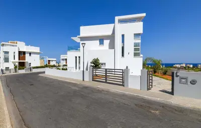 a white house with a driveway in front of it at Mylos Lifestyle Seaview Villa #37 in Protaras