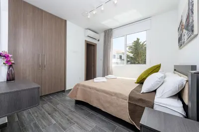 a bedroom with a large bed and a window at Green Bay Villa #15 in Protaras