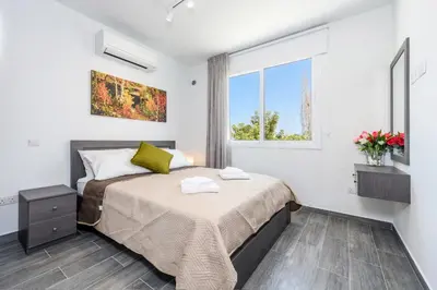 a bedroom with a bed and a window at Green Bay Villa #15 in Protaras