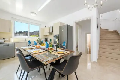 a kitchen and dining room with a table and chairs at Green Bay Villa #16 in Protaras