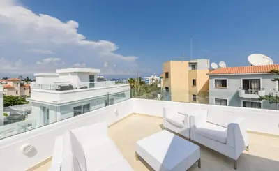 a balcony with white furniture and a view of the city at Green Bay Villa #16 in Protaras
