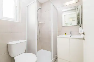 a white bathroom with a shower and a toilet at Green Bay Villa #17 in Protaras