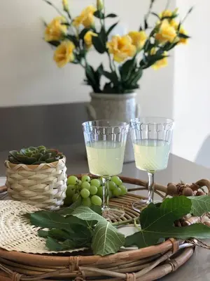 a table with two wine glasses and a basket of grapes at Villa Greco Mare #6 in Protaras