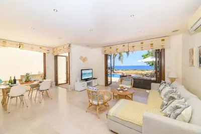 a living room with a couch and a table with chairs at Villa Greco Mare #6 in Protaras