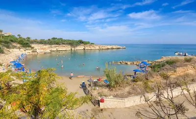 a beach with a bunch of people in the water at Villa Clementine in Protaras
