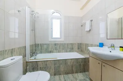 a bathroom with a tub and a toilet and a sink at Villa Hannah in Protaras