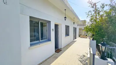 a white building with a window and a walkway at The Lemon Tree Hostel in Larnaka