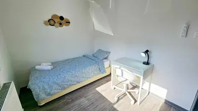 a small bedroom with a bed and a table at The Lemon Tree Hostel in Larnaka