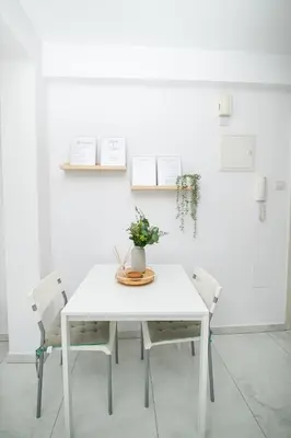 a white table with two chairs and a vase on it at Quattro City Center Ap 501B in Larnaka