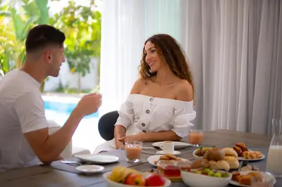 a man and a woman sitting at a table with food at City Napa Seaview Villas - Villa 5 in Ayia Napa