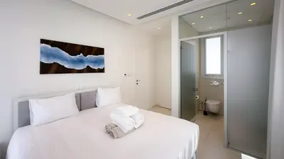 a bedroom with a white bed and a bathroom at City Napa Seaview Villas - Villa 5 in Ayia Napa