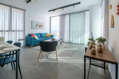 a living room with a blue couch and a table at Gaia Seaview Apartment 2 in Larnaka