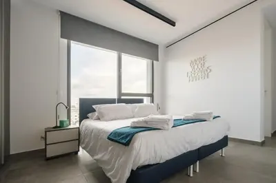 a bedroom with a bed and a large window at Gaia Seaview Apartment 2 in Larnaka