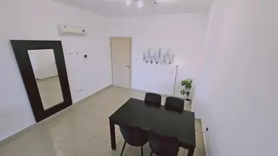 a dining room with a black table and a mirror at STAY White Petals Apartment in Larnaka