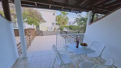 a patio with a table and chairs on a porch at STAY Blissful Apartment in Protaras