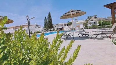 a pool with chairs and umbrellas at a resort at STAY Blissful Apartment in Protaras