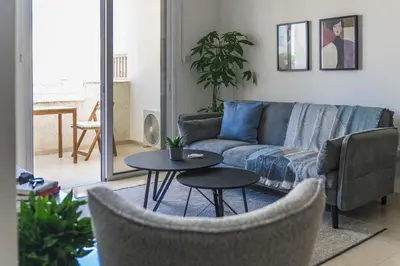 a living room with a couch and two tables at Creative 1br Pool view Apt with covered parking in Livadhia