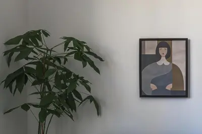 a plant sitting next to a picture of a woman at Creative 1br Pool view Apt with covered parking in Livadhia