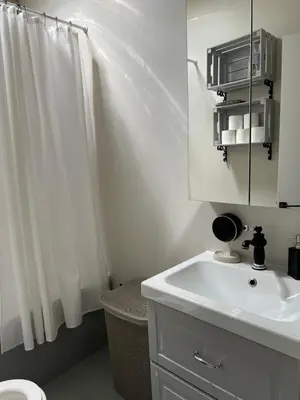 a white bathroom with a sink and a mirror at The Fig Tree House in Lofou