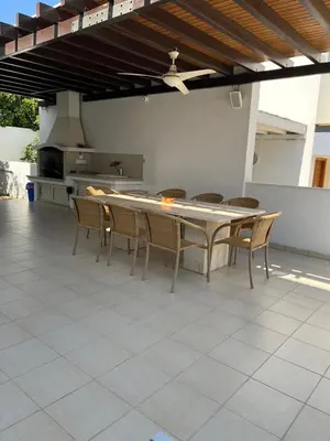 a patio with a table and chairs and a kitchen at POSEIDONIA BEACH GARDENS in Paralimni