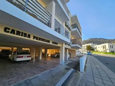 a building with cars parked in a parking lot at STEFARIS sea & mountain view in Larnaka