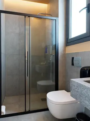 a bathroom with a glass shower with a toilet at Alinea Market Agora Square in Limassol