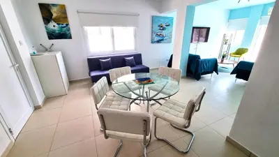 a living room with a glass table and chairs at City Center: Your Urban Retreat- 100m to the beach in Larnaka